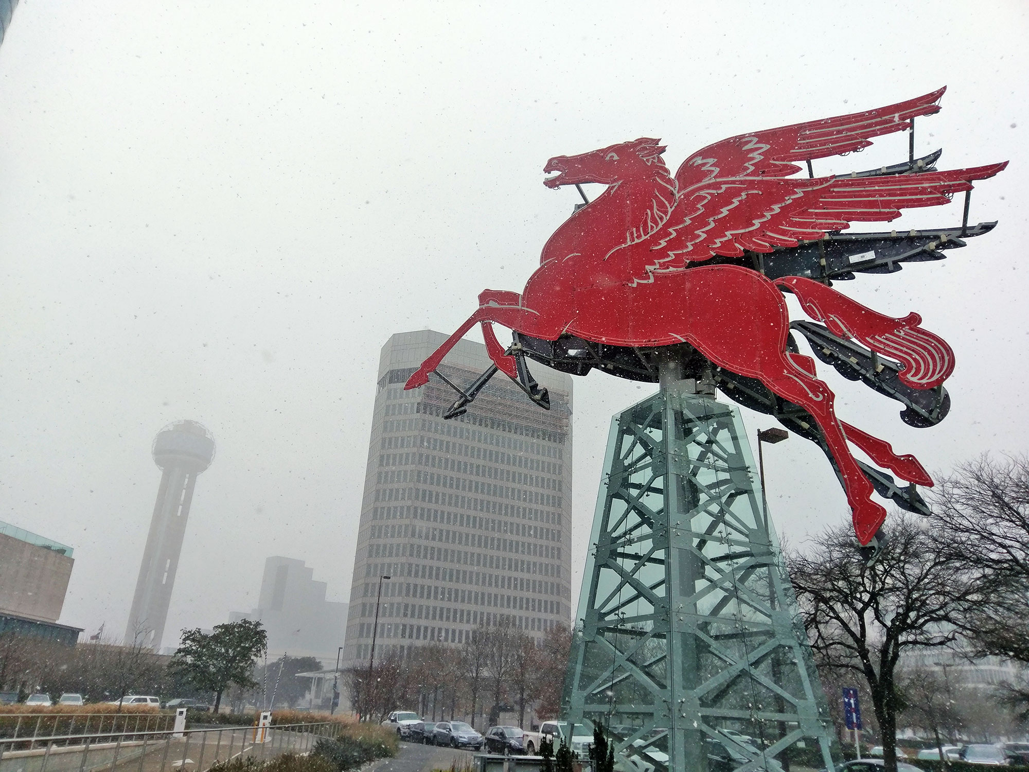 Snow falls in front of the Omni Hotel in downtown Dallas.