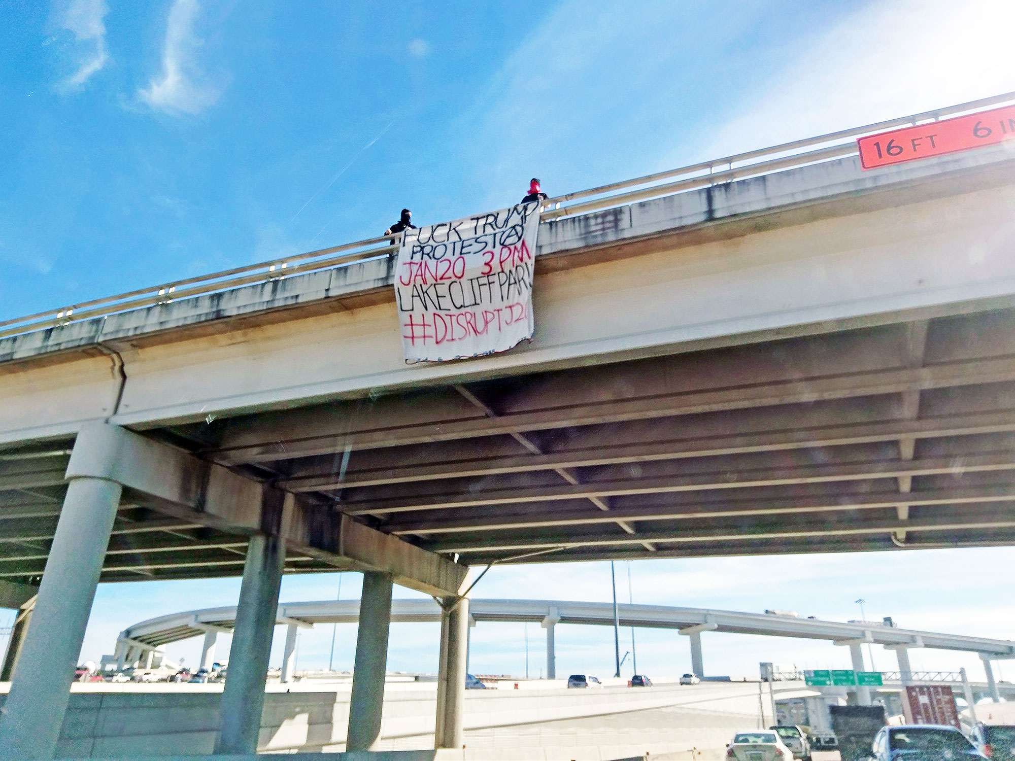 Trump protesters hang a sign off of a Dallas highway.